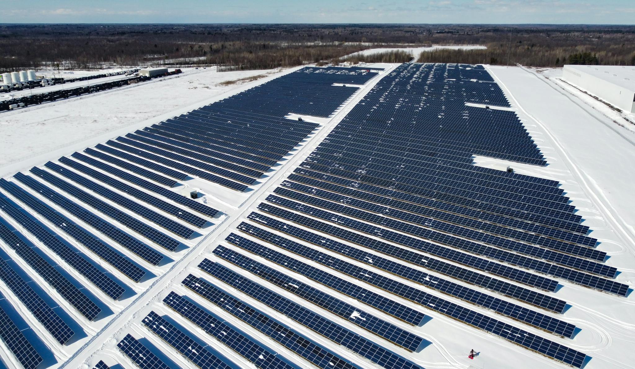 A drone-captured image of a large solar farm in Kingston, Canada, surrounded by snow.